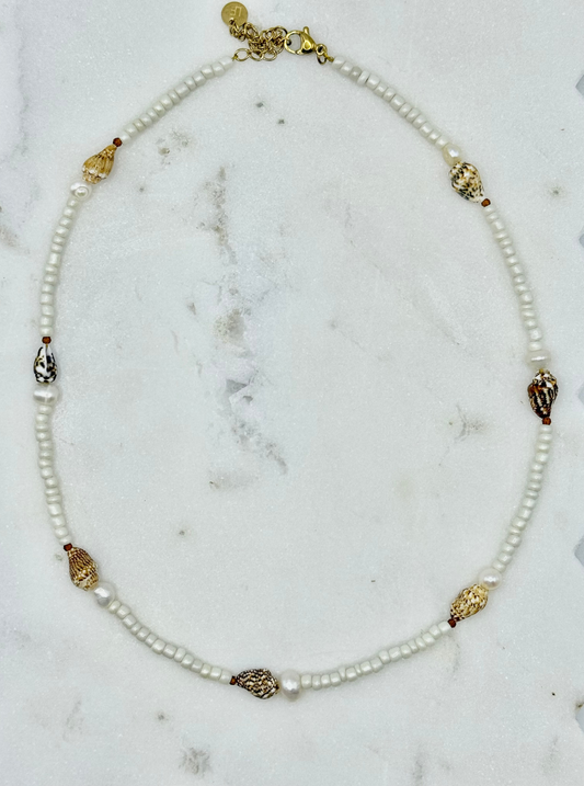 Pearl necklace with gold accents on a marble surface