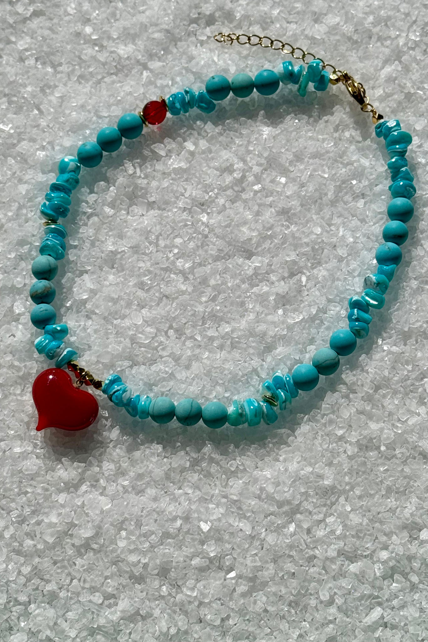 Turquoise beaded necklace with a red heart charm