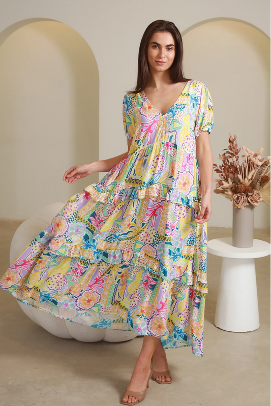 Woman wearing colorful floral Cindy Midi Dress by Solara Boheme with V-neck and flowing tiered skirt