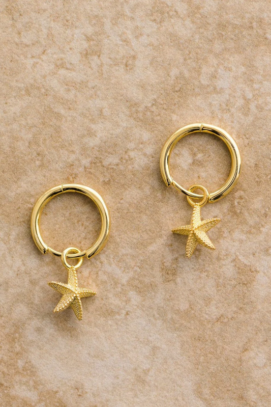 Starfish Earrings by Solara Boheme, gold plated hoops with detailed starfish charms on a textured background