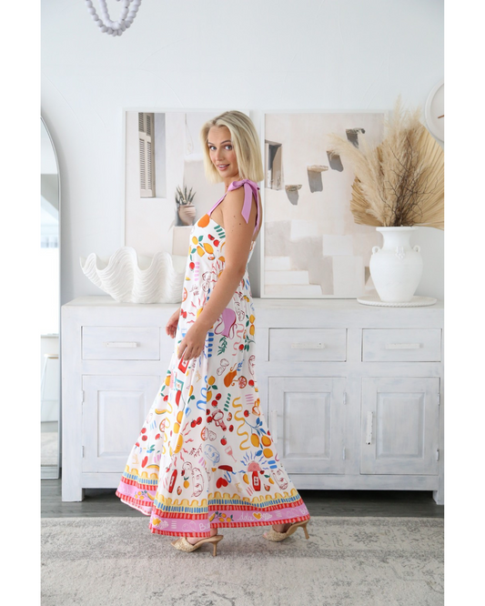 Woman wearing colorful Sunprint Maxi Dress from My Store with adjustable straps and airy A-line skirt in bright room