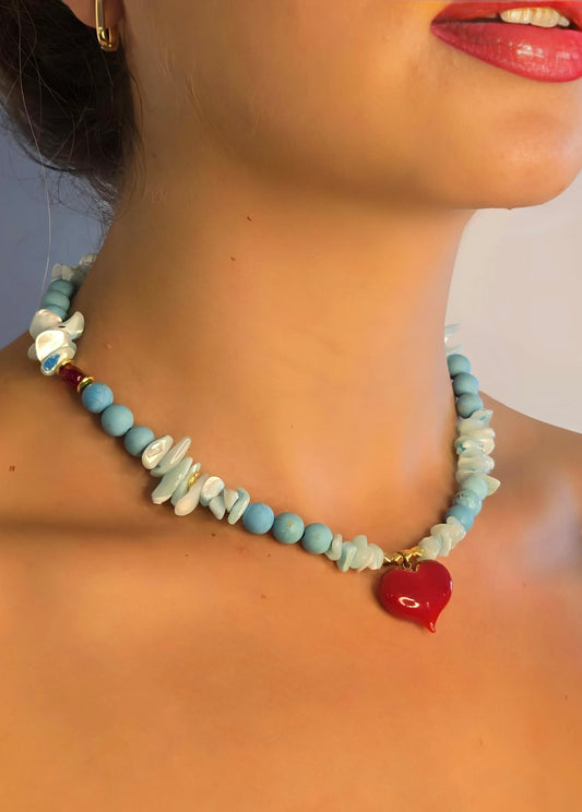 Necklace with blue and red heart pendant worn by a model