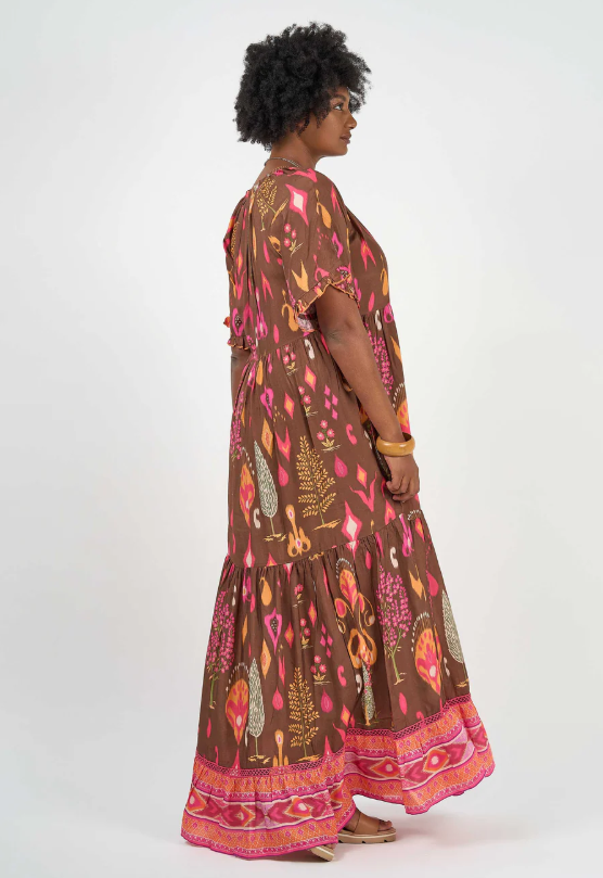 Woman wearing Solara Boheme Amisha Delta Maxi Dress in earthy tones with vibrant pink accents and flowing tiered design