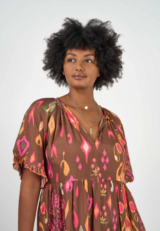 Woman wearing an Amisha Delta Maxi Dress by Solara Boheme with vibrant earthy print and flowing relaxed fit