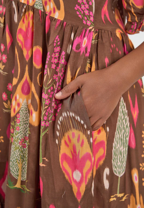 Close-up of hand in pocket on Solara Boheme Amisha Delta Maxi Dress with vibrant print and flowing viscose fabric