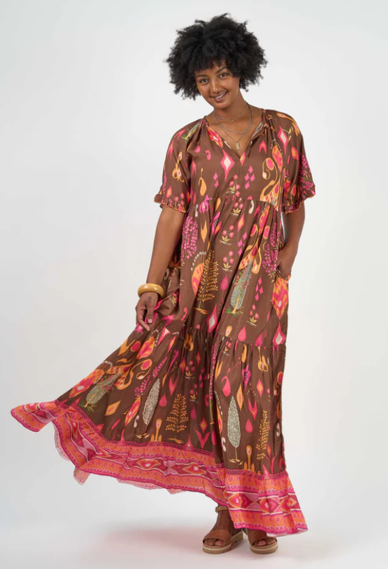 Smiling woman wearing Solara Boheme Amisha Delta Maxi Dress with vibrant earth tones and flowing tiers