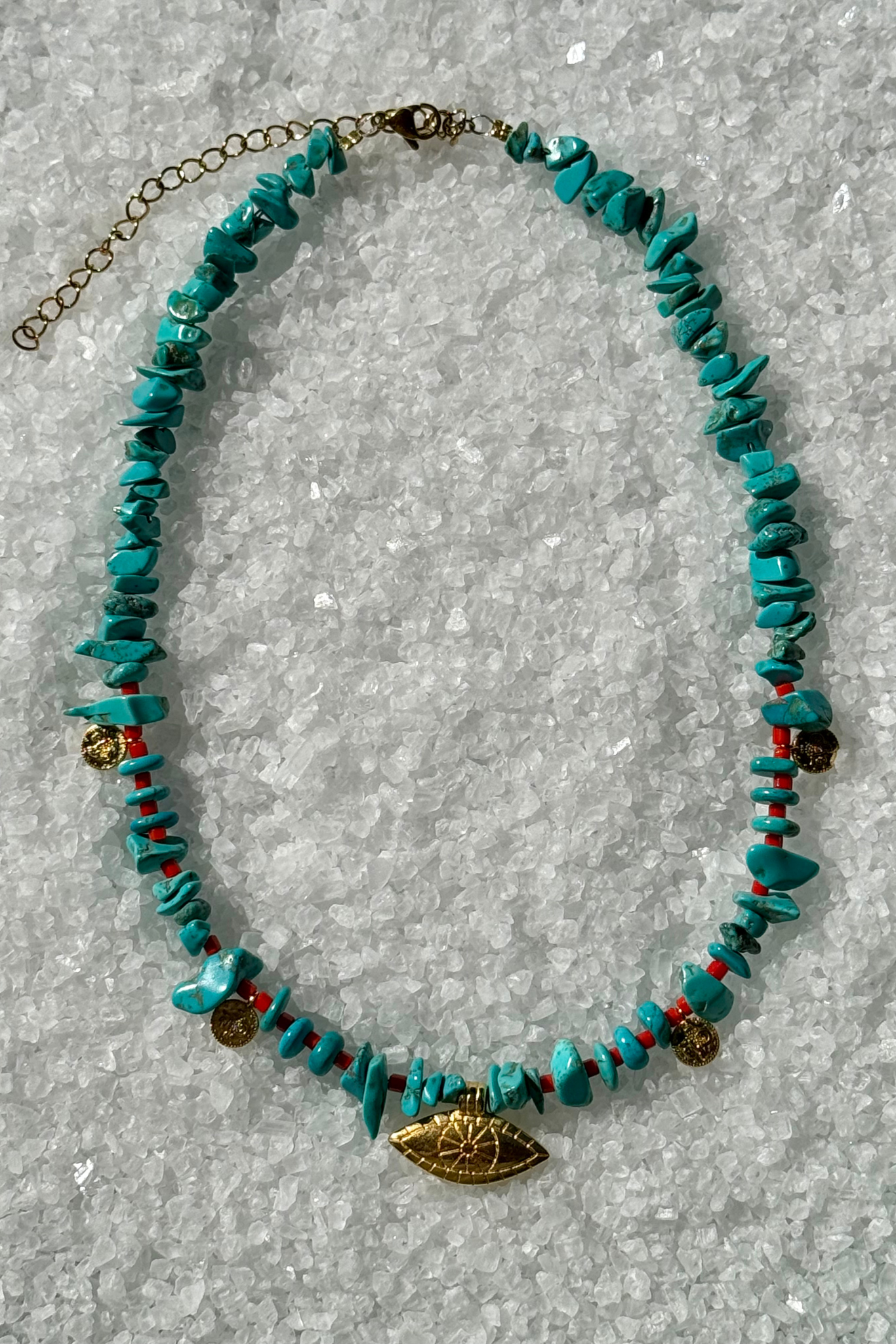 Turquoise beaded necklace with gold and red accents and evil eye