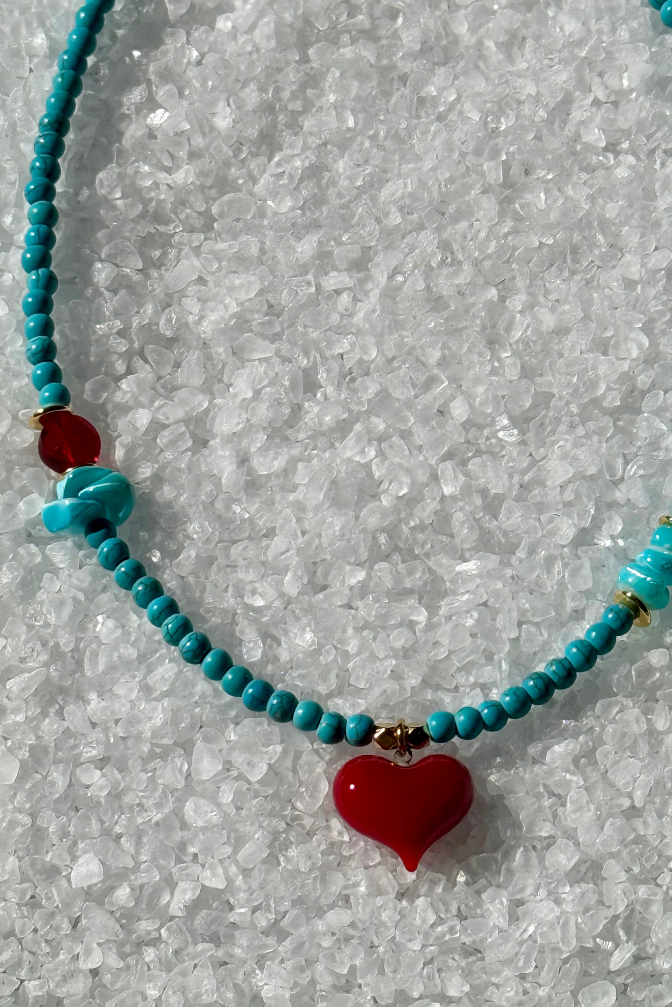 Turquoise beaded necklace with a red heart pendant 
