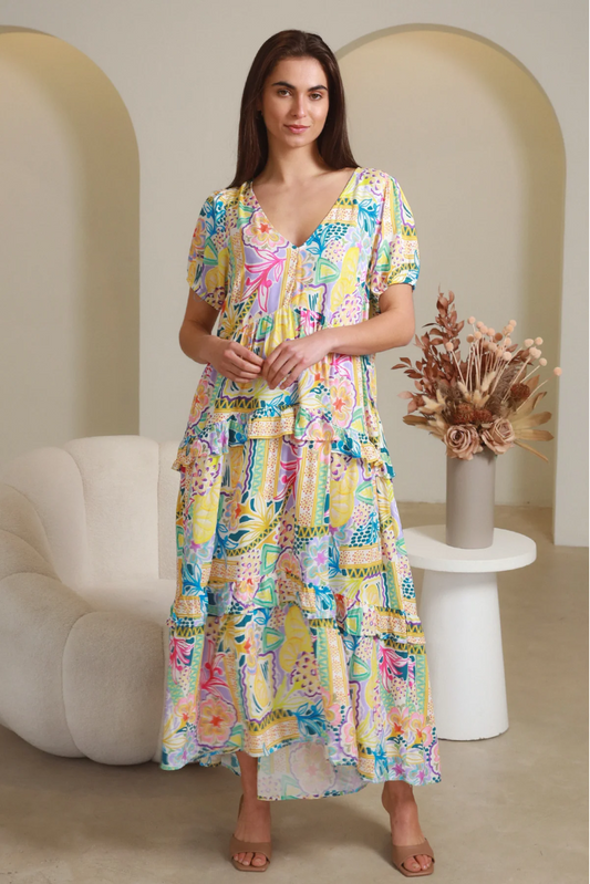 Woman wearing Solara Boheme Cindy Midi Dress with colorful pattern and relaxed fit in a modern room setting