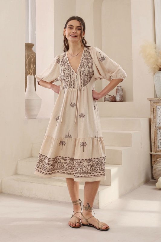 Woman wearing Desert Palm Midi Dress by Solara Boheme with embroidered palm details and 3/4 sleeves in neutral setting