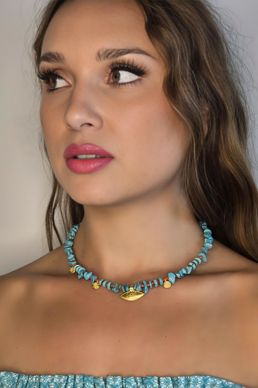 Woman wearing a blue beaded necklace with a plain background