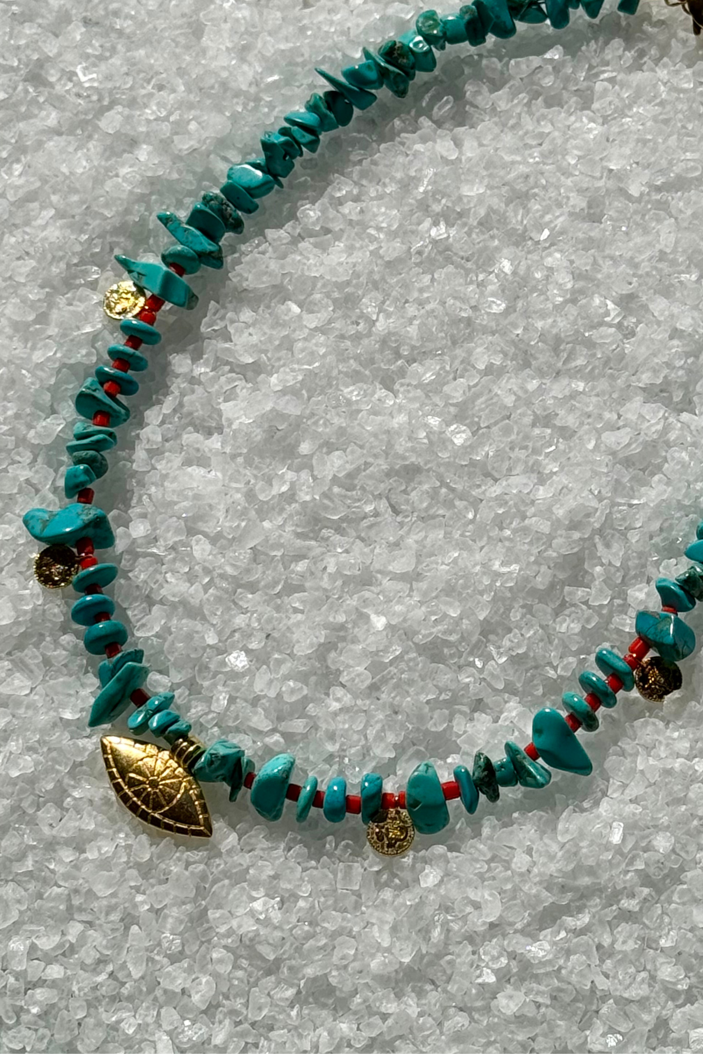 Turquoise beaded necklace with gold and red accents and evil eye