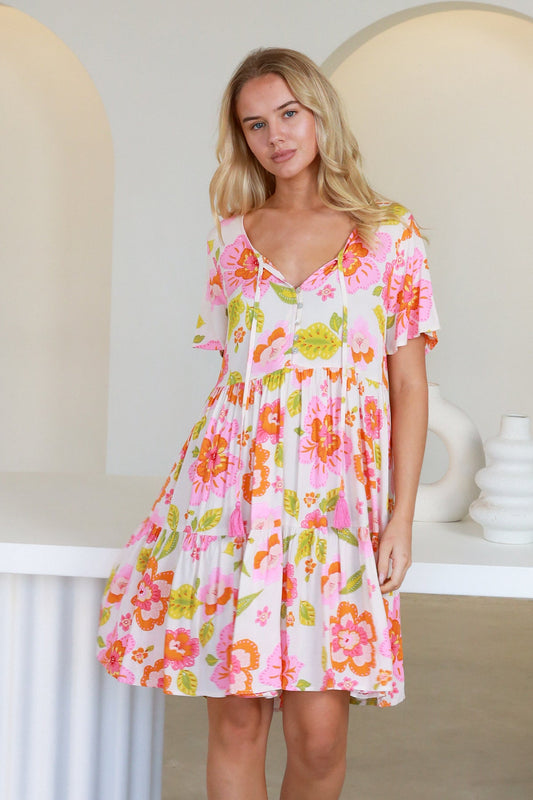 Woman wearing a breathable, soft, oversized Freya Mini Dress with a colorful floral print and short sleeves.