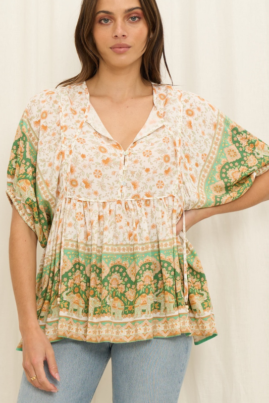 Woman wearing Solara Boheme Ishka Blouse with floral print, green border, V-neck, and relaxed fit in soft breathable fabric