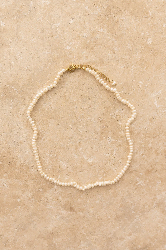 Kaia Necklace by My Store featuring elegant freshwater pearls and gold plated clasp on a beige stone surface.