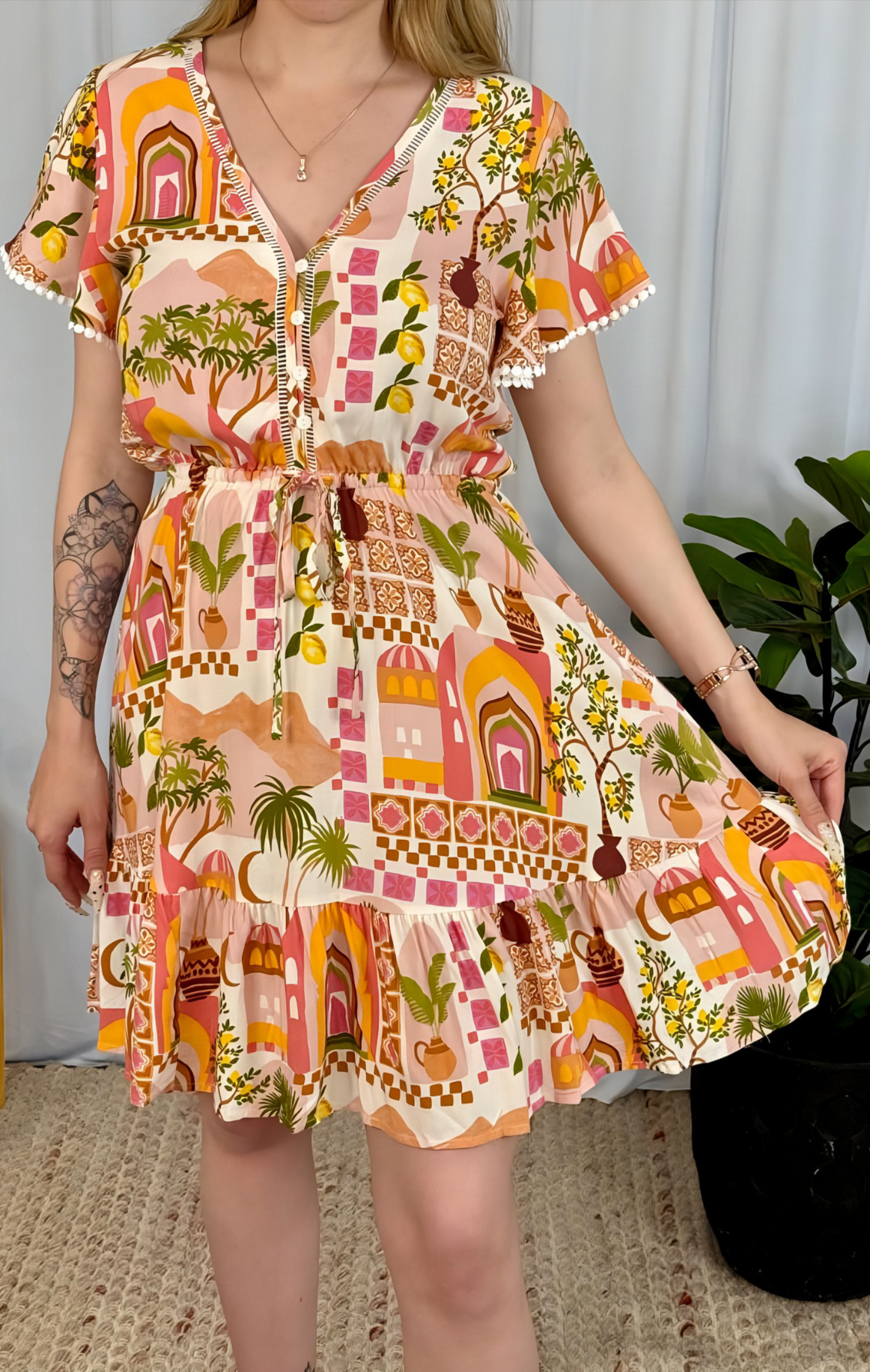 Layla Mini Dress by Solara Boheme with vibrant palm tree and archway print, button front and flutter sleeves.