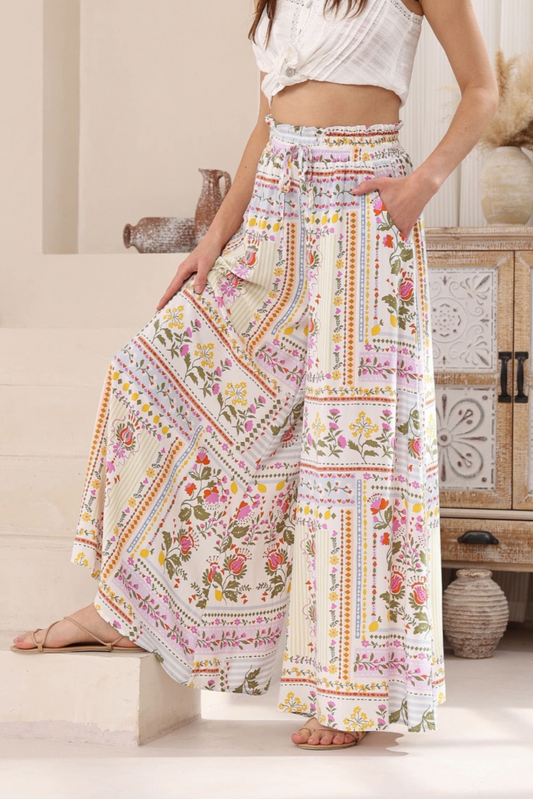 Lila Pant by Solara Boheme featuring wide leg design, floral print, deep pockets, and elasticated waistband with drawstring detail