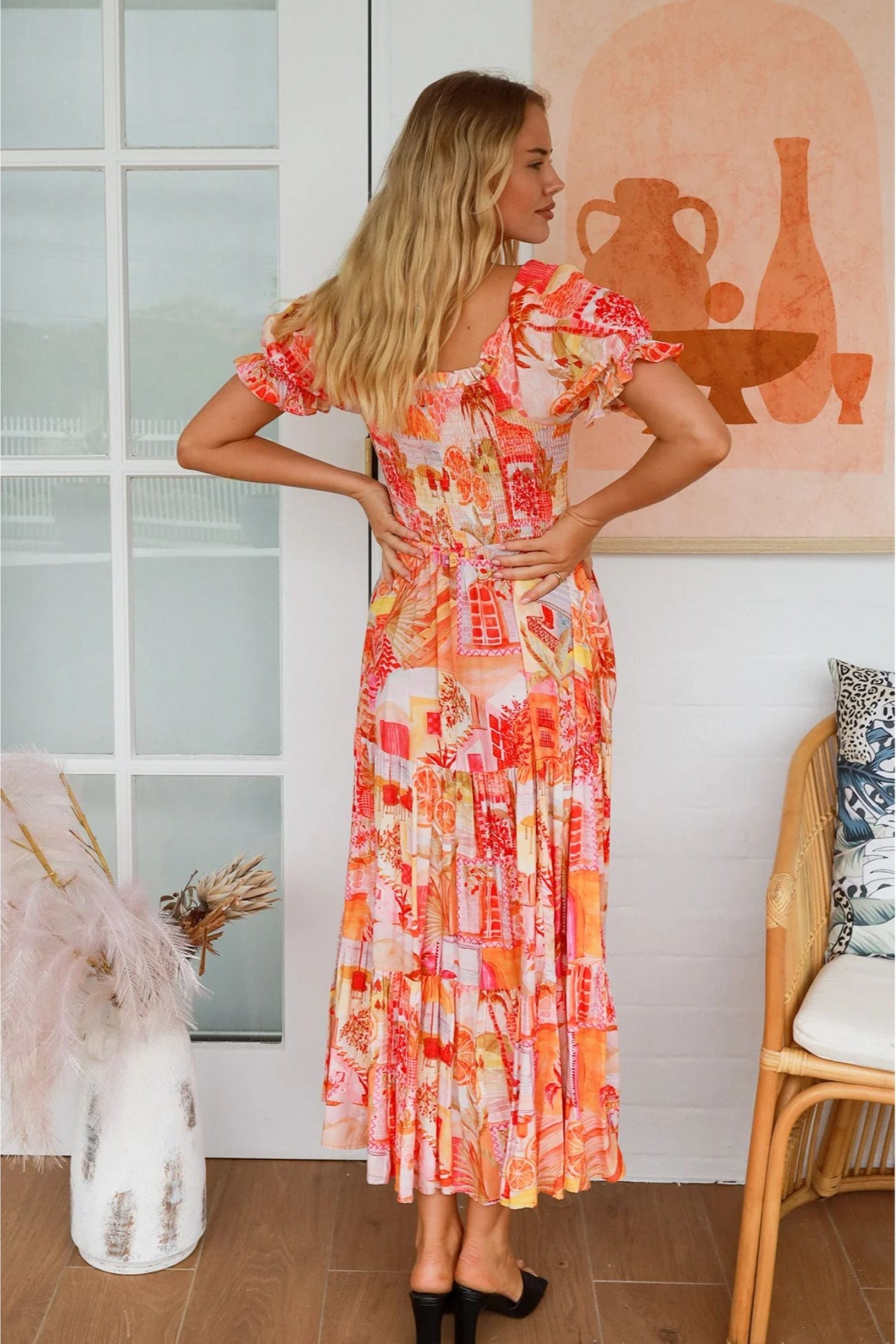 Woman wearing Maribel Maxi Dress with vibrant print standing by door in cozy room by My Store