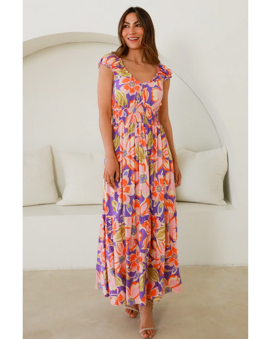 Woman wearing colorful floral Mira Maxi Dress by My Store standing indoors with neutral background