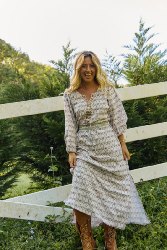 Woman smiling outdoors wearing Solara Boheme Palm Springs Maxi Dress with nature-inspired print and long sleeves