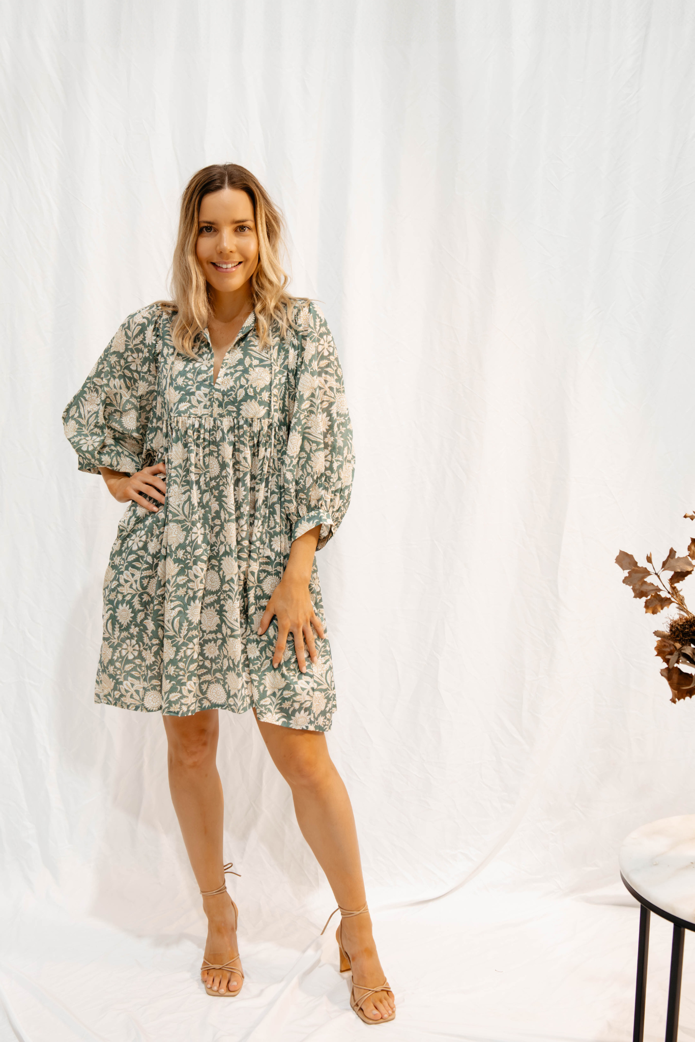 Woman wearing Solara Boheme Sara Mini Dress with floral hand block print in soft olive green cotton voile