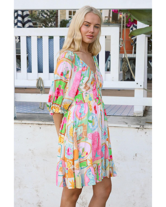 Woman wearing a colorful Scarlett Mini Dress by My Store outdoors with floral and abstract patterns