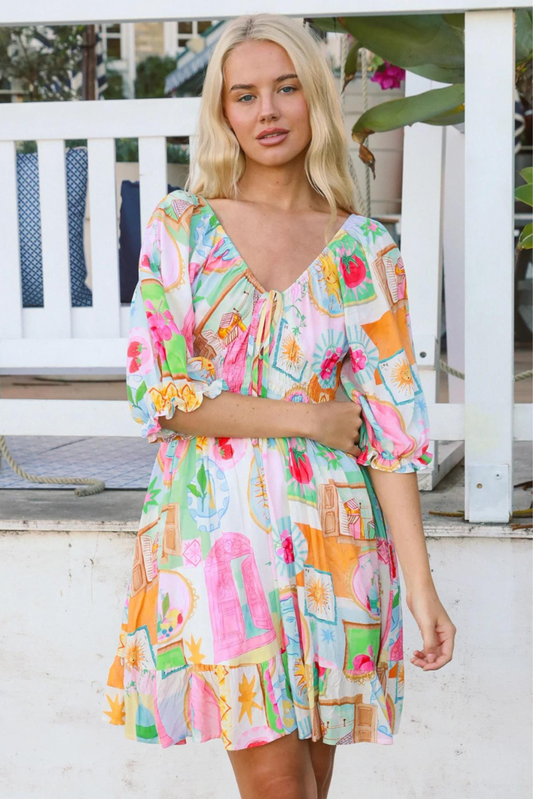 Model wearing colorful Scarlett Mini Dress by My Store with puff sleeves and a gathered waist detail outdoors.