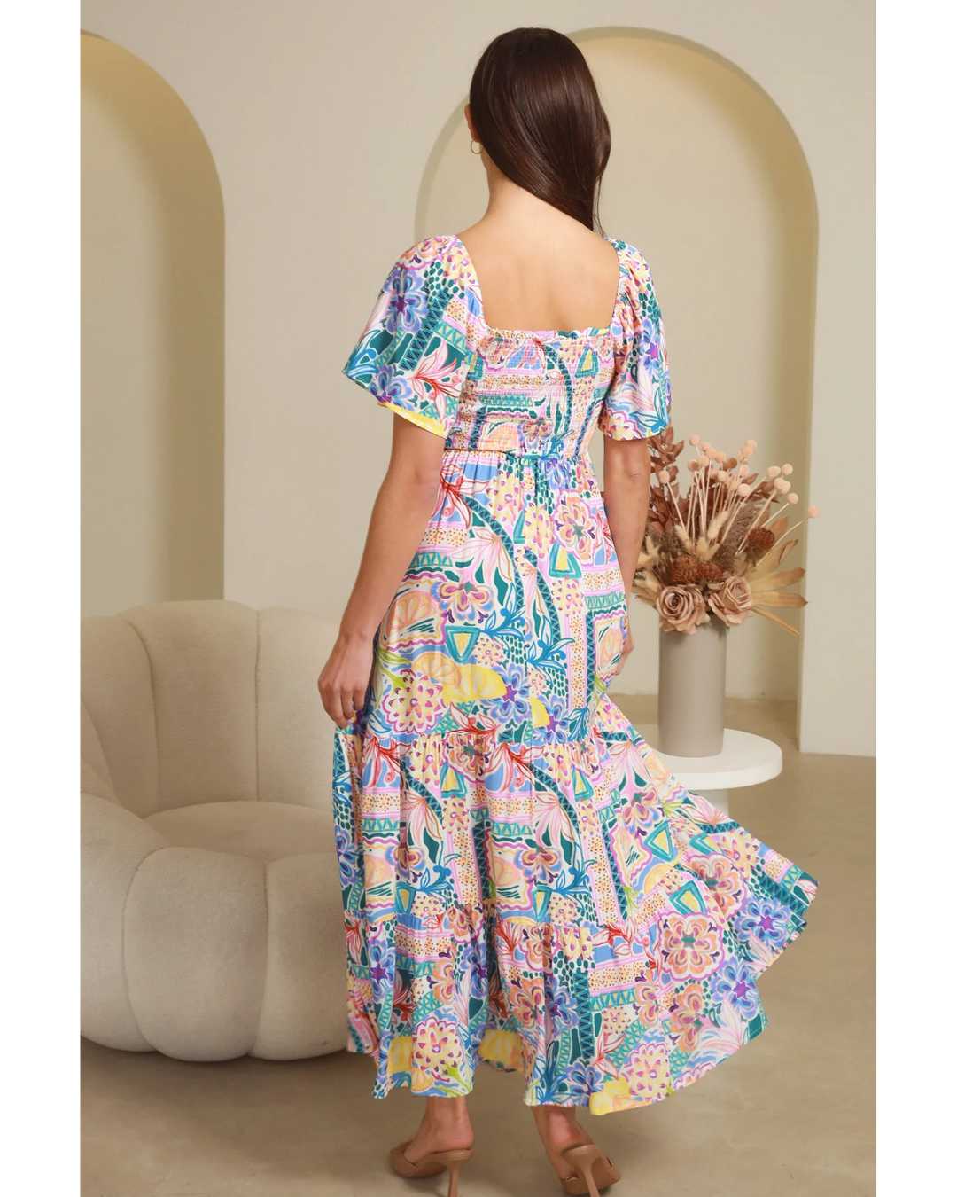 Woman wearing Sharon Short Sleeves Maxi Dress by My Store with colorful floral pattern and flutter sleeves standing indoors