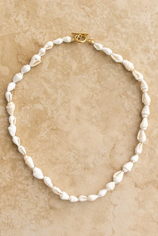 Shelley Necklace by Solara Boheme featuring delicate seashells and 18Kt gold plated clasp on natural textured background