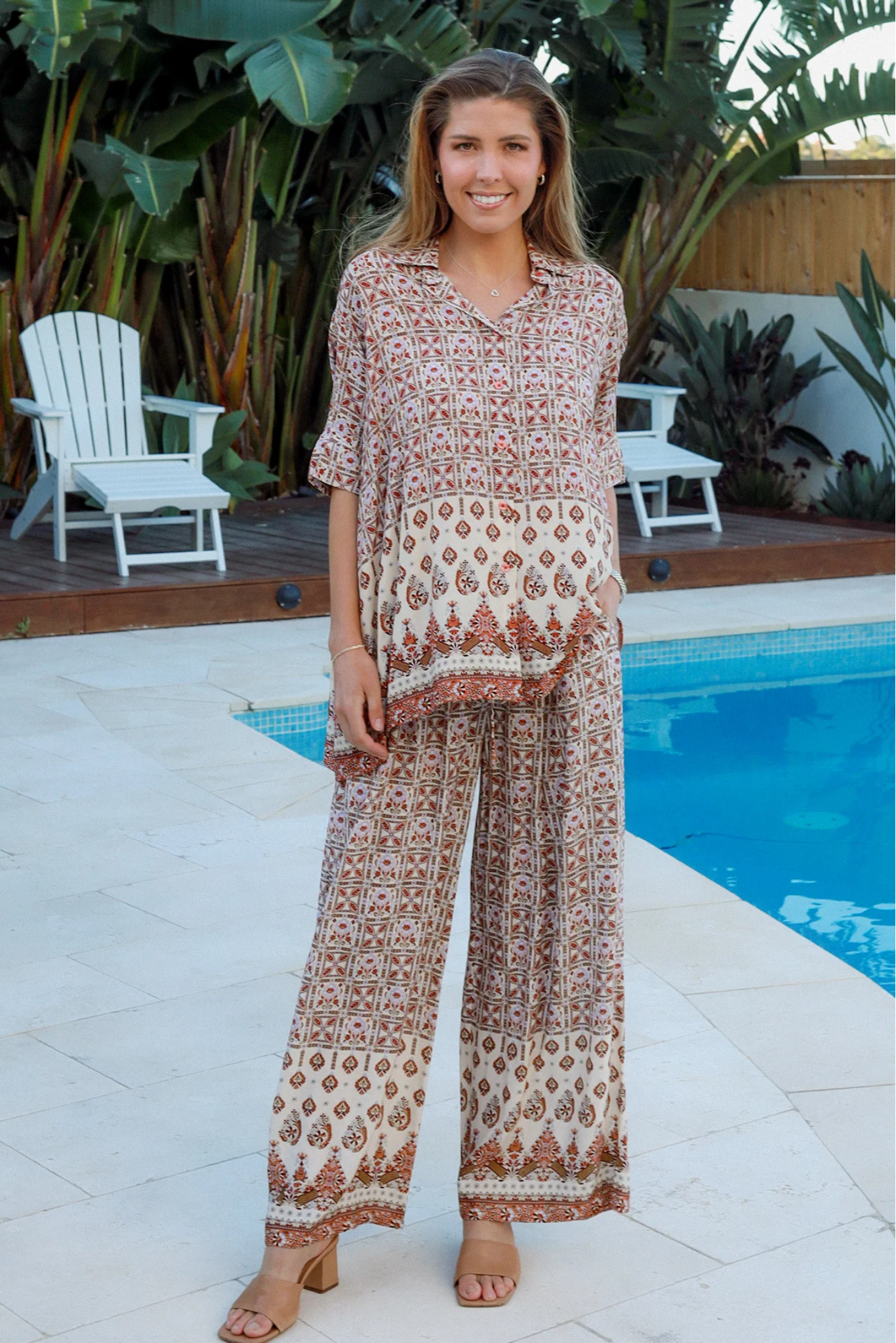 Woman standing by pool wearing patterned Tori Pants from My Store in a relaxed outdoor setting
