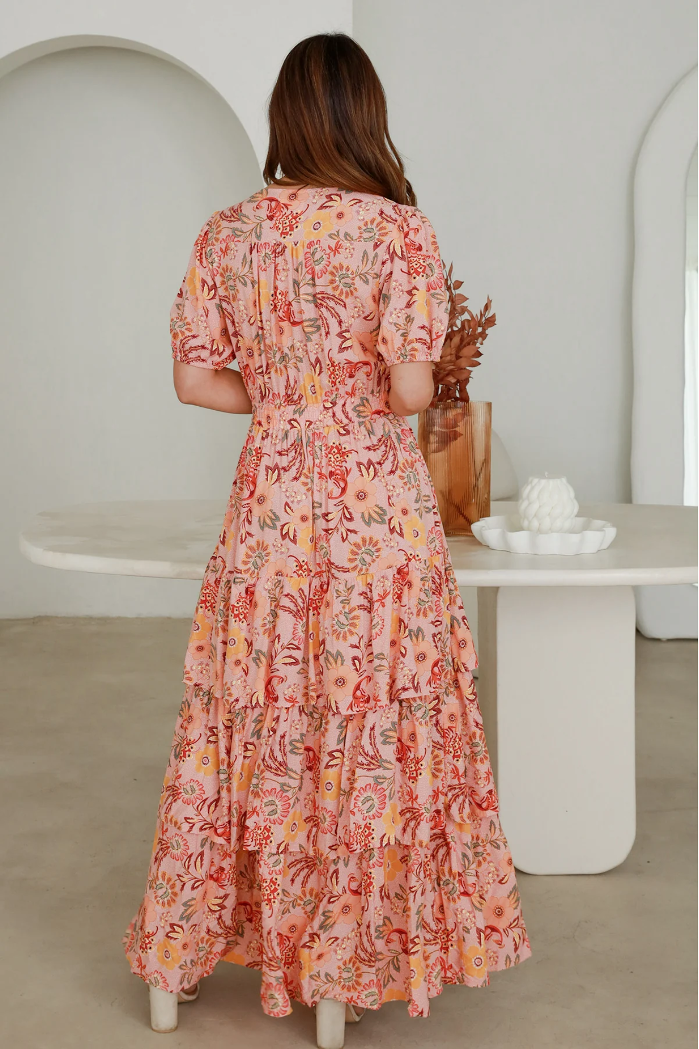 Back view of Vera Maxi Dress by Solara Boheme with floral print and tiered skirt design in a soft pink shade