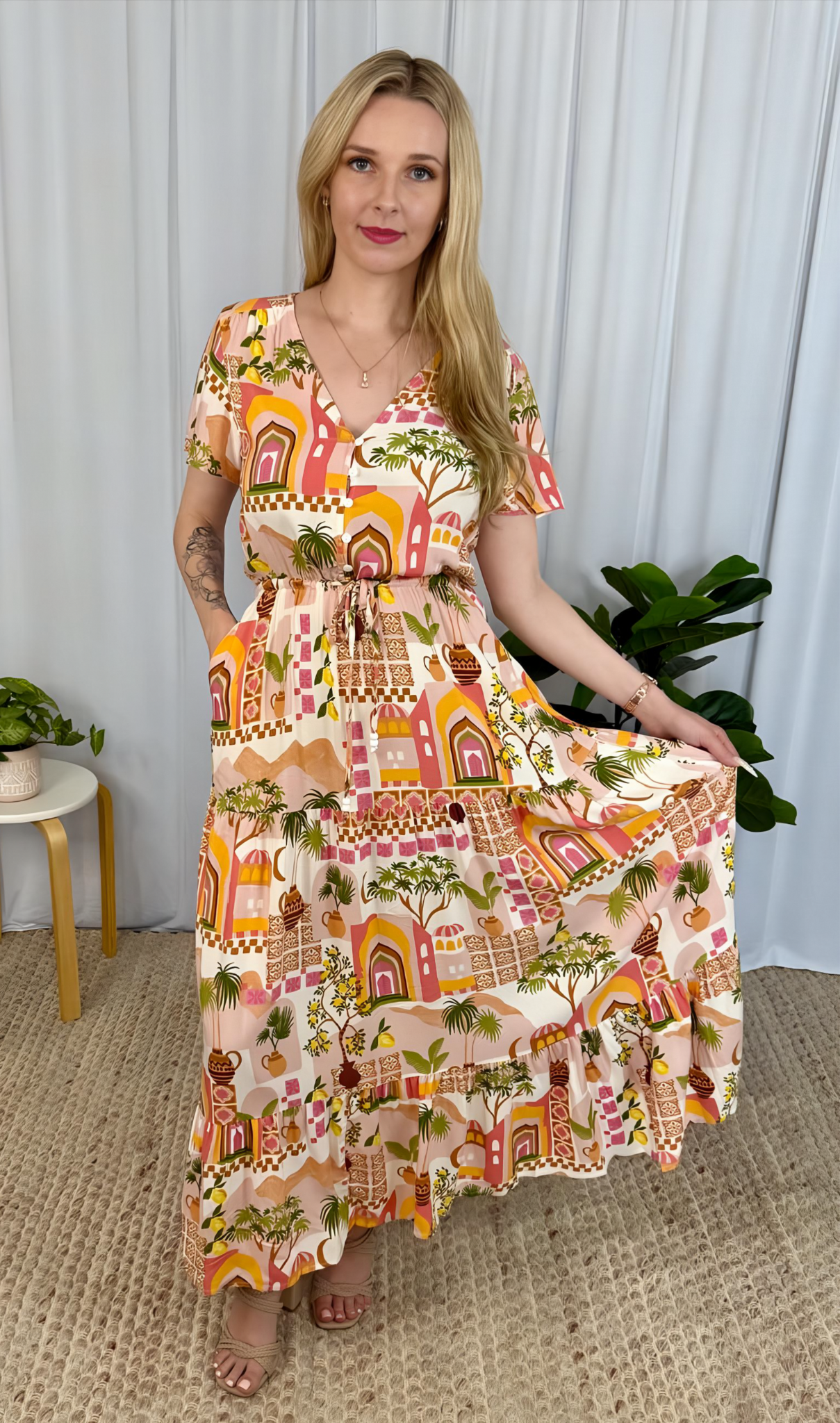 Woman wearing Solara Boheme Yasmin Maxi Dress with vibrant sunset print and adjustable waist in a bohemian style setting