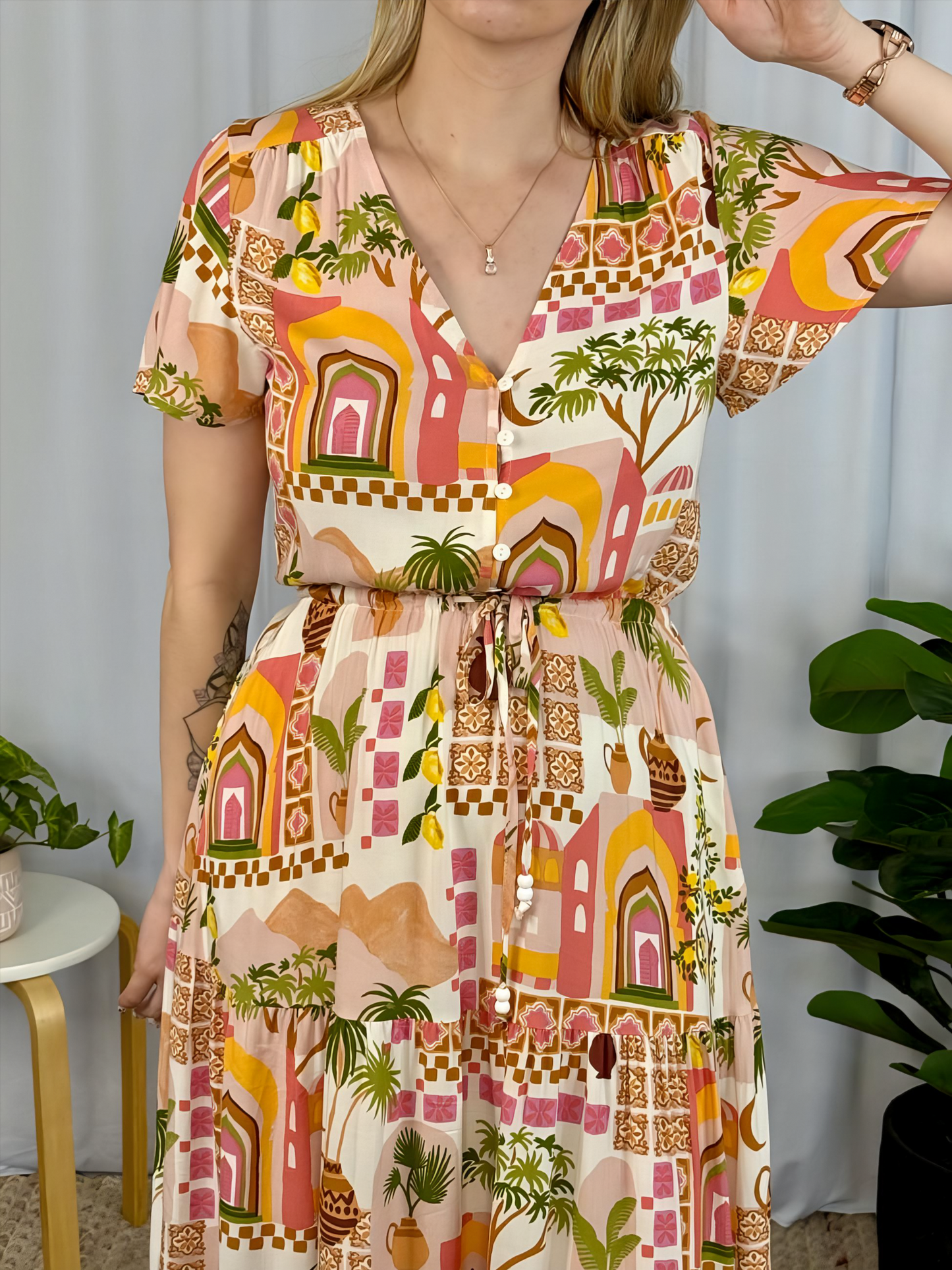 Yasmin Maxi Dress by Solara Boheme featuring vibrant print, V neckline, button front, drawstring waist, and tiered skirt with pockets